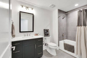 Modern gray and white bathroom with sleek vanity, tiled shower, and minimalist contemporary design.