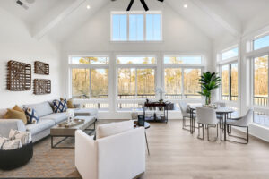 Bright modern living and dining room with vaulted ceiling, large windows, and natural light.
