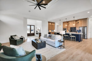 Modern open-concept living room and kitchen with natural light, wood finishes, and elegant decor.