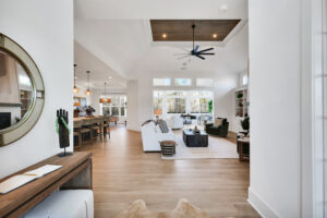 Modern open-concept living room with natural light, warm wood floors, and contemporary furnishings.