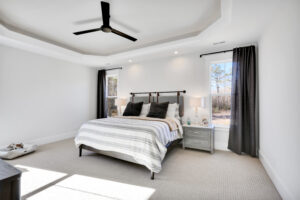 Bright modern minimalist bedroom with neutral décor, large bed, natural light, and elegant wood accents.